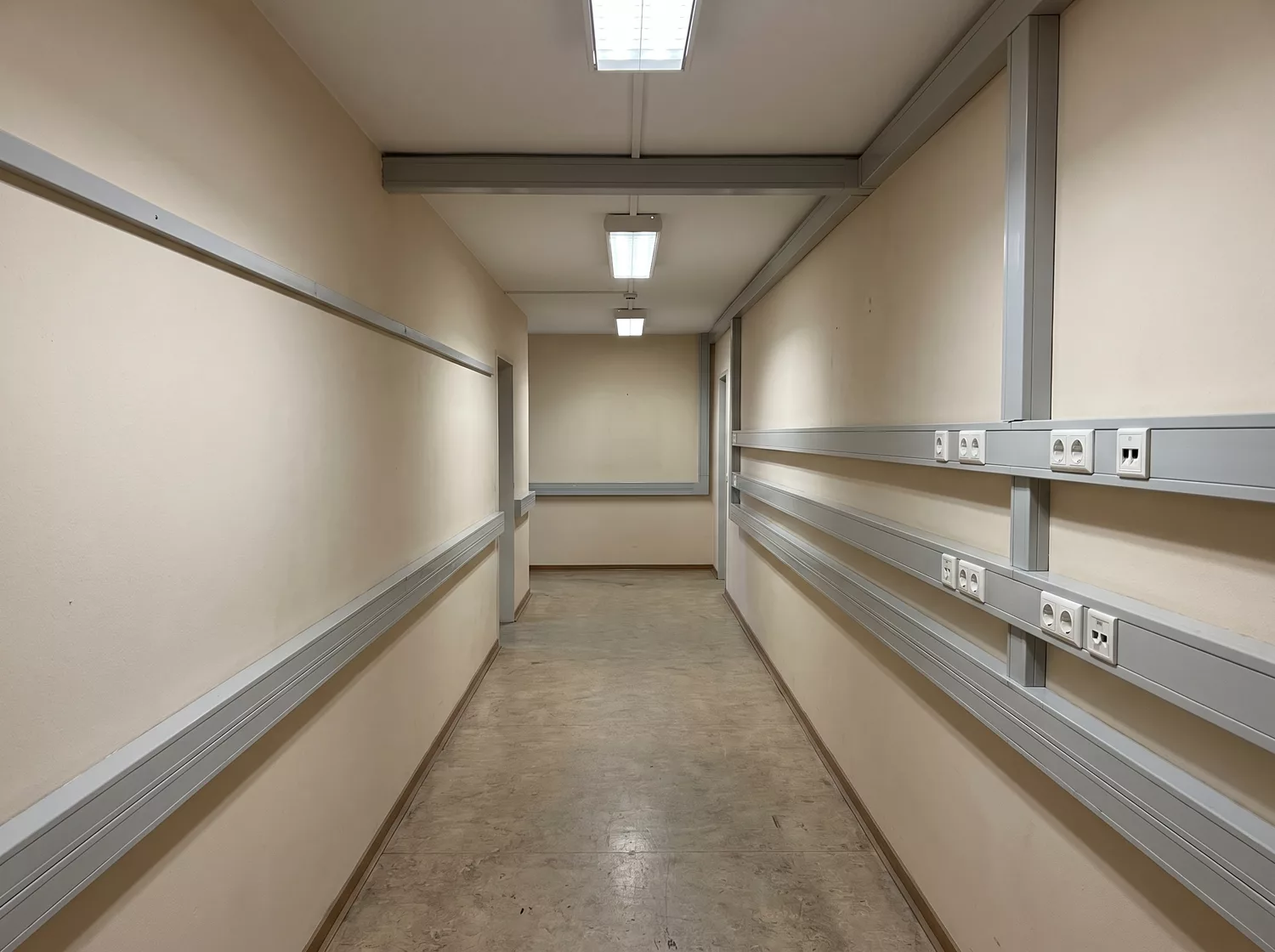 Gewerbeflur mit Aufputz-Kabelkanal, Deckenleuchten und Steckdosenreihe