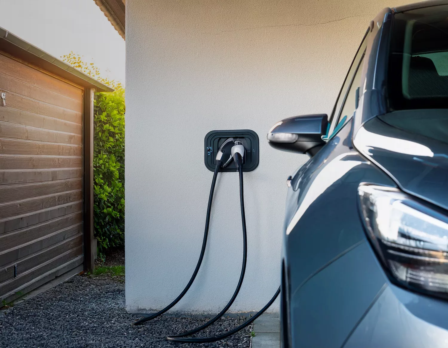 Wandladestation am Carport eines Einfamilienhauses mit aufgerolltem Kabel